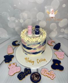 a baby shower cake decorated with cookies and icing