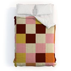 a bed covered in a pink, yellow and brown checkered comforter