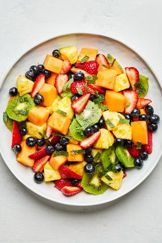 a white bowl filled with fruit salad on top of a table