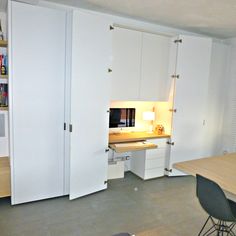 a room with white cupboards and a desk