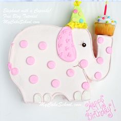 a birthday cake shaped like an elephant with a cupcake in its trunk and a candle on top