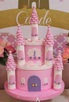 a pink castle cake sitting on top of a table