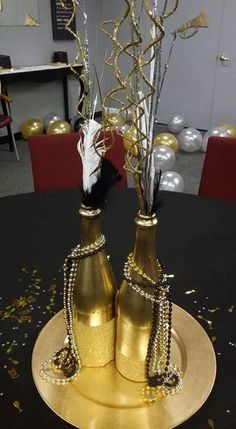 two gold vases on a black table with confetti