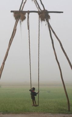 a person on a swing in the middle of a field