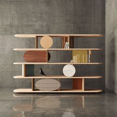 a book shelf with books and other items on it in an empty room next to a concrete wall