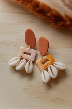 two pairs of shell earrings on a table