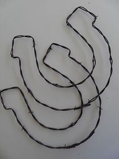 a drawing of a bunch of bananas on a white wall with barbed wire around it