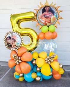 the number five is surrounded by balloons and other decorations in front of a garage door