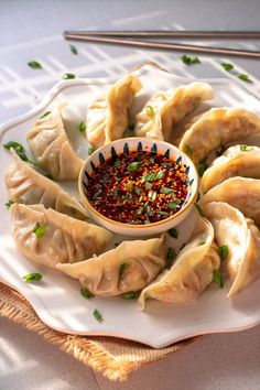 a white plate topped with dumplings covered in sauce