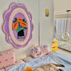 a cat laying on top of a bed next to stuffed animals and a wall hanging