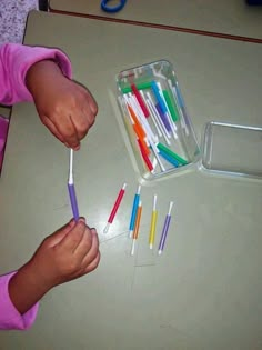 a child is holding several toothbrushes in their hands