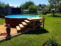 an above ground swimming pool with steps leading up to it and a deck in the middle