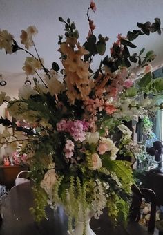 a vase filled with lots of flowers on top of a table