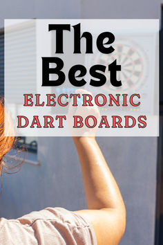 a woman holding up a sign that says the best electronic dart boards