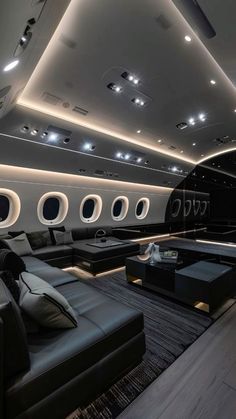 the interior of an airplane with couches, tables and lights on it's ceiling