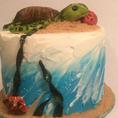 there is a cake decorated with sea animals and sand on the bottom, including a turtle