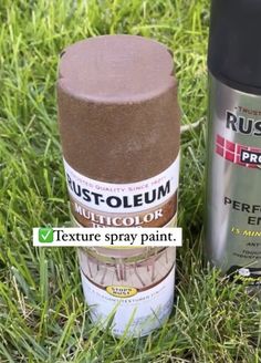 two cans of rust - oleum paint sitting in the grass next to each other