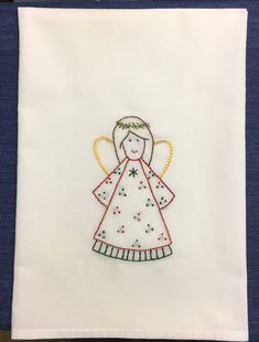 an embroidered angel on a white piece of cloth