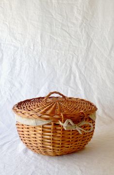 a wicker basket sitting on top of a white sheet