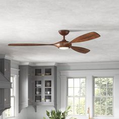 a ceiling fan in the middle of a kitchen with gray cabinets and white counter tops