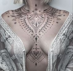 a woman with tattoos on her chest and back