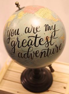 a globe with the words you are my greatest adventure on it sitting on a wooden stand