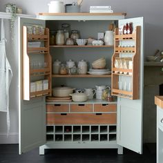 an open cabinet in a kitchen filled with dishes