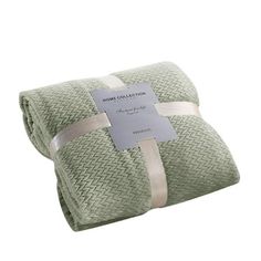 the home collection blanket in sage green is folded and ready to be put on display