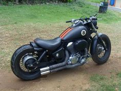 a black motorcycle parked on top of a dirt road