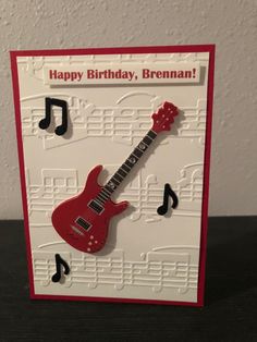 a birthday card with a red guitar and musical notes on the front, happy birthday, brenan