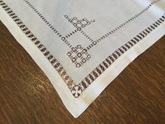 two white napkins on top of a wooden table