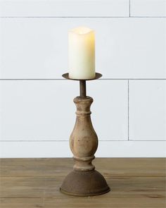 a white candle sitting on top of a wooden table