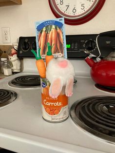 carrots in a carton sitting on top of a stove next to a can of carrots