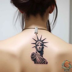 the statue of liberty tattoo on the back of a woman's upper body is shown