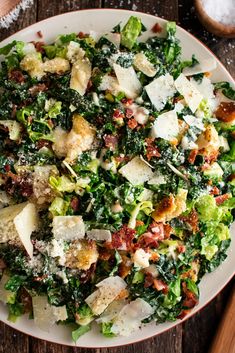 a white bowl filled with lots of food on top of a wooden table