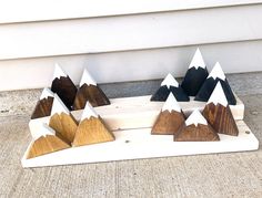 five wooden mountains sitting on top of a white board