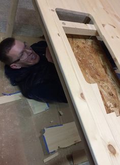 a man laying on the ground next to wooden planks