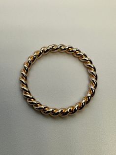 14K gold filled band made of twisted wire. Band is 2 pieces of 1.3mm gold filled wire. Cut, bent, soldered and polished in my studio.  The combined width is about 2.6mm.  Handmade in USA. Made with high-quality materials, this ring is both durable and stylish. Whether you're dressing up for a special occasion or adding some flair to your everyday look, this ring is sure to turn heads. Don't miss out on this must-have accessory! Modern Twisted 14k Gold Jewelry, 14k Gold Twisted Modern Jewelry, Gold Twisted Stackable Jewelry, 14k Gold Twisted Jewelry, Modern Twist 14k Gold Twisted Jewelry, Adjustable Gold Braided Jewelry, Adjustable Braided Yellow Gold Jewelry, Gold Braided Ring, Gold Rope Ring