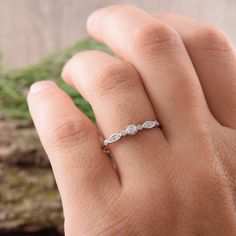 a woman's hand with a diamond ring on it