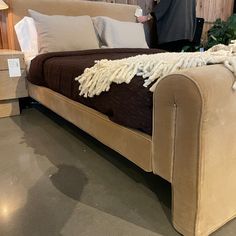 a bed that is on display in a room with wood paneling and furniture behind it