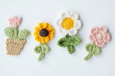 three crocheted flowers sitting next to each other