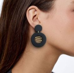 Circular earrings in black and golden brass, light, exclusive and modern design. These handmade earrings are a perfect combination of modern style and minimalist geometric design. With clean lines and symmetrical shapes, these earrings have a contemporary look that fits perfectly for any occasion. In addition, their lightweight makes them comfortable to wear all day long. These modern earrings will be an ideal addition to any occasion. These earrings are unique and one-of-a-kind. They are carefu Minimalist Black Drop Earrings, Minimalist Black Linear Drop Earrings, Black Minimalist Metal Earrings, Trendy Black Geometric Earrings, Modern Black Geometric Earrings, Symmetrical Shapes, Circular Earrings, Brass Light, Ceramic Earrings