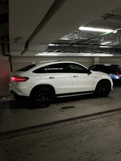 two cars parked in a parking garage with no one around them or on the ground