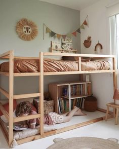 two children sitting on the bottom bunk of a bed in a child's bedroom