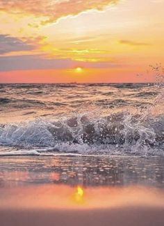 the sun is setting over the ocean with waves crashing in front of it and an orange sky