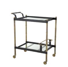 a black and gold serving cart with two glass shelves on casteors, one holding a tray