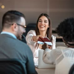 a woman handing something to a man at a table