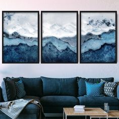 three paintings hang on the wall above a couch in a living room with a coffee table