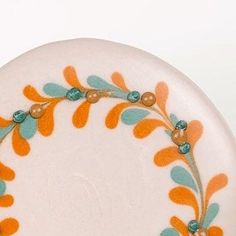 a white plate with orange and blue designs on it