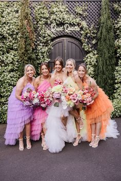 the bridesmaids are all wearing different colored dresses